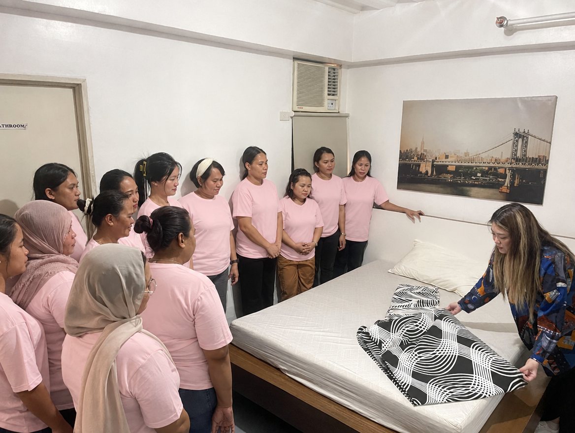 Helpers practising bed-making during training